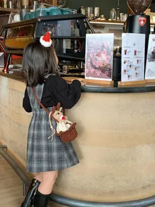 Détail d'un petit sac bandoulière en crochet motif cerf pour enfant dans un café