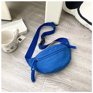 Detail of blue canvas kids waist bag with nylon strap and woven rope zipper pull