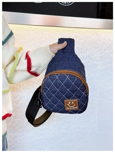 Dettaglio del tessuto denim blu con cuciture a rombi e toppa Smile Denim in pelle