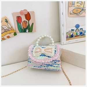 Detailed view of colorful tweed mini bag with pearl handle and bow accent detail