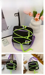 Detail view of black nylon crossbody bag with purple straps and neon green cord detailing