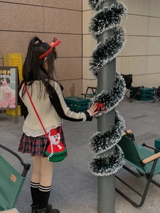 Détail d'un sac bandoulière Père Noël fait main au crochet avec couleurs festives rouge vert