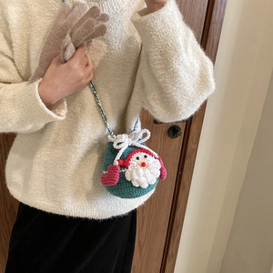 Handmade crochet Santa Claus bucket bag in dark green worn with winter outfit