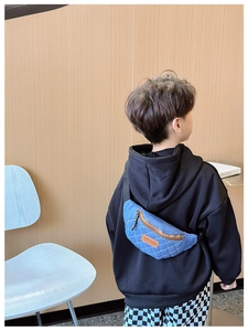 Dettaglio del borsello in denim trapuntato per bambini con tracolla regolabile e patch