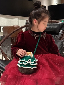 Détail d'un enfant portant un sac bandoulière sapin de Noël en crochet fait main