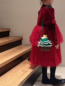 Détail d'un enfant portant un petit sac bandoulière en crochet en forme de sapin de Noël festif