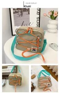 Detail of khaki kids crossbody bag with green nylon strap and orange decorative cord