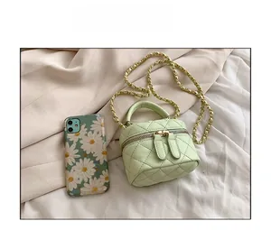 Detail of mint green quilted mini chain bag with gold chain strap and top handle