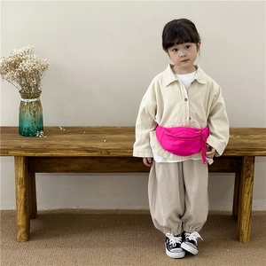 Rose pink canvas kids fanny pack worn by a child in a minimalist home setting