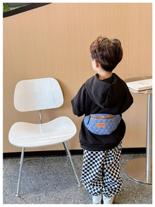 Dettaglio vista posteriore di un borsello in denim trapuntato per bambini con pelle marrone