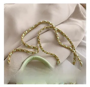 Detail show of light green quilted crossbody bag with gold metal woven chain strap