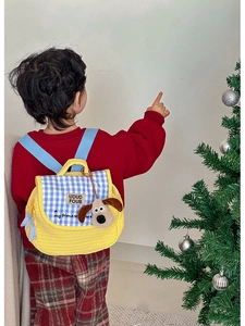 Quilted yellow child backpack with blue checkered flap and brown plush puppy charm
