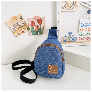 Dettaglio borsa pettorale denim per bambini con trapuntatura a rombi e patch smile