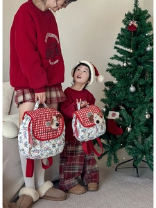 Detail of red checkered quilted parent-child backpacks with cute plush puppy pendant