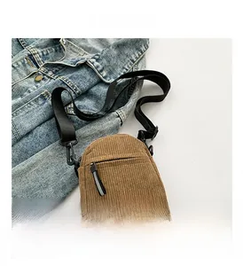 Détail d'un petit sac bandoulière en velours côtelé marron avec sangle en nylon