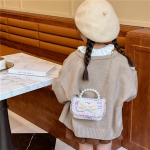 Kids colorful tweed mini handbag with bow, pearl handle and gold chain strap shown on model