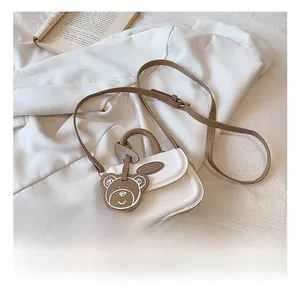 Dettaglio di una mini borsa in pelle PU bianca con un simpatico ciondolo a forma di orso