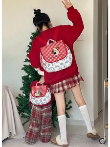 Detail of parent-child quilted backpacks with cartoon dog motif and red plaid flaps