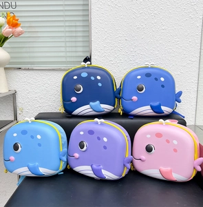 Row of colorful cartoon whale backpacks in various vibrant shades displayed on a shelf