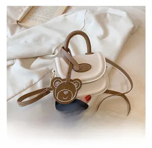 Dettaglio della mini borsa coreana color crema con ciondolo a orso e tracolla lunga