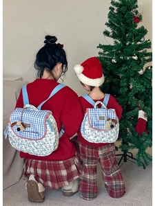 Detail of matching quilted plaid backpacks for parent and child with cute puppy charms