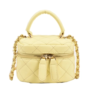 Mini yellow quilted vanity bag with top handle and gold chain strap in boxy style
