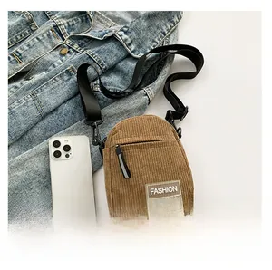 Petit sac bandoulière en velours côtelé marron comparé à un téléphone portable