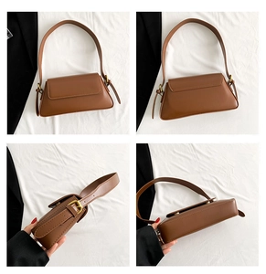 Detail view of brown faux leather shoulder bag with adjustable strap and gold metal buckle