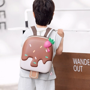 Cute ice cream shaped children backpack with pink strawberry charm shown on kids back