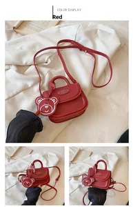 Dettaglio mini borsa rossa a tracolla per bambini con logo Hello e ciondolo orso
