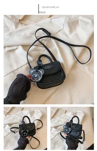 Dettaglio della mini borsa in pelle PU nera con ciondolo a forma di orso e tracolla