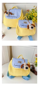 Detail of yellow quilted kids backpack with blue checkered flap and plush dog charm