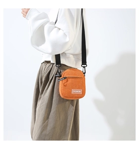 Détail du petit sac bandoulière en velours côtelé orange avec étiquette Fashion