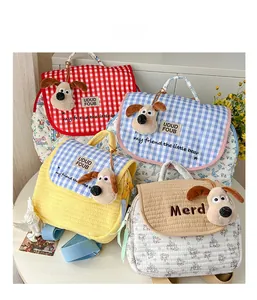 Detail view of quilted children backpacks with dog plush charms in various plaid patterns