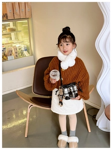 Girl wearing a black and white checkered bucket bag with a cute rabbit doll pendant