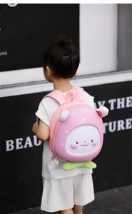 Pink cartoon eggshell backpack featuring 3D ears and strawberry leaves on kid model