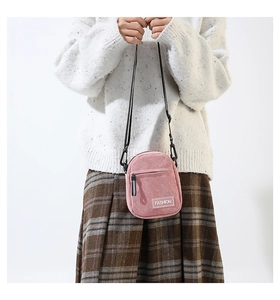 Détail du sac bandoulière en velours côtelé rose avec étiquette Fashion et sangle