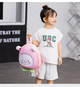 Close-up of cute pink bunny egg-shaped hardshell backpack on a child model outdoors