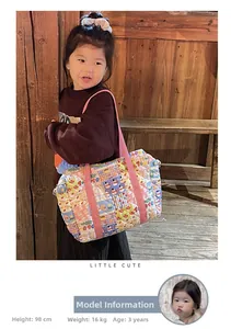 Close-up of a 3-year-old child carrying a quilted floral patchwork crossbody bag