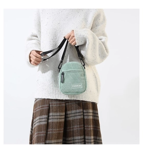 Détail du mini sac bandoulière en velours côtelé vert clair avec étiquette mode et sangle