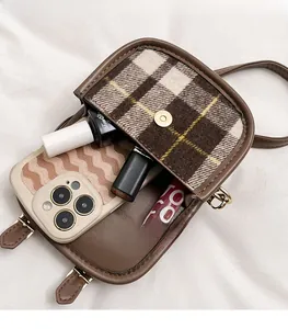 Vue intérieure du mini sac à carreaux montrant l'espace pour téléphone et maquillage
