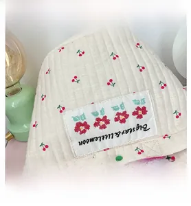 Détail d'un sac à main matelassé pour enfants avec motifs cerises et broderies fines