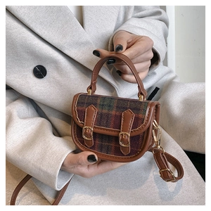 Détail d'un mini sac à main à carreaux marron avec tissu en laine et boucles métal