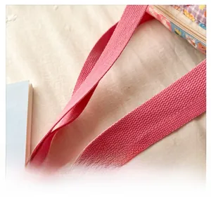 Close-up of durable pink woven strap and floral pattern on kid's crossbody bag