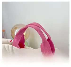 Détail du sac cabas matelassé en coton avec motif cerises et poignées roses souples