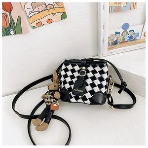 Detail of checkered girls' bucket bag with cute rabbit plush charm and fashion label