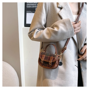 Détail du mini sac à carreaux avec garniture en cuir marron et boucles en métal doré