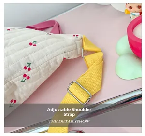 Détail de la bandoulière réglable en nylon jaune avec boucle argentée sur sac floral