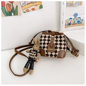 Close-up of brown checkered drawstring bucket bag with a cute plush rabbit charm
