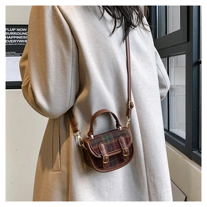 Mini sac bandoulière à carreaux tartan avec détails en cuir porté par un mannequin